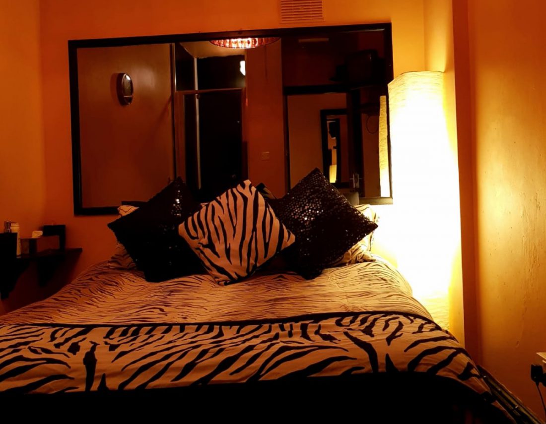 Room with a double bed and yellow lighting
